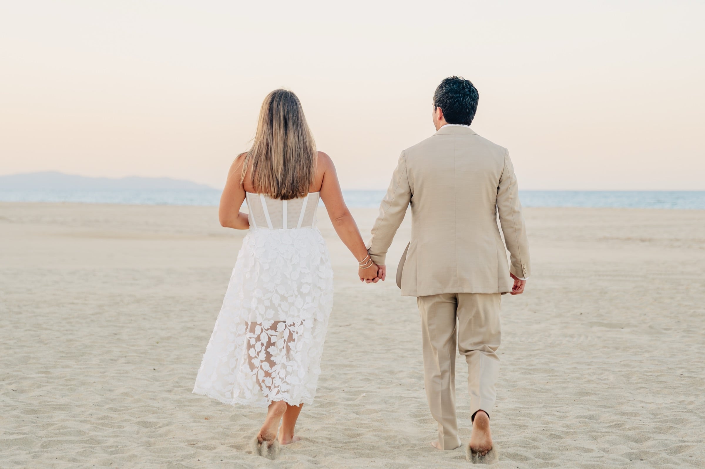 Taylor and Jeffrey walking on the beach at sunset